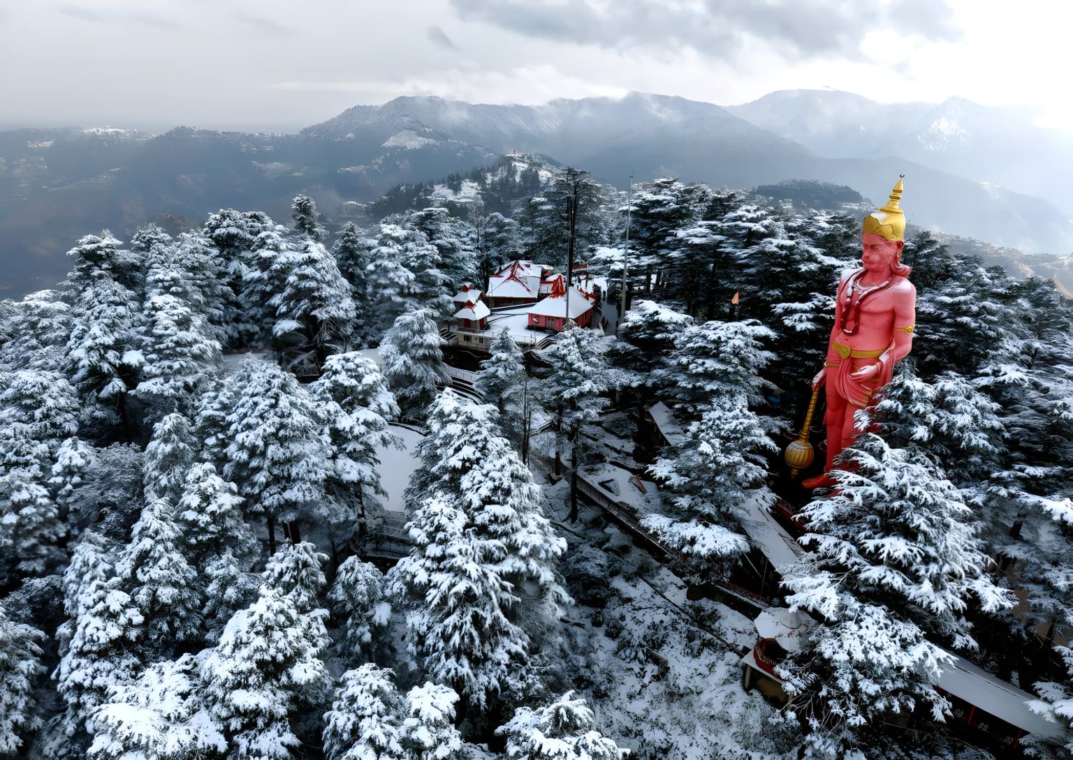 Jakhoo Temple's Hanuman statue rising above snow-covered deodar forests in Shimla